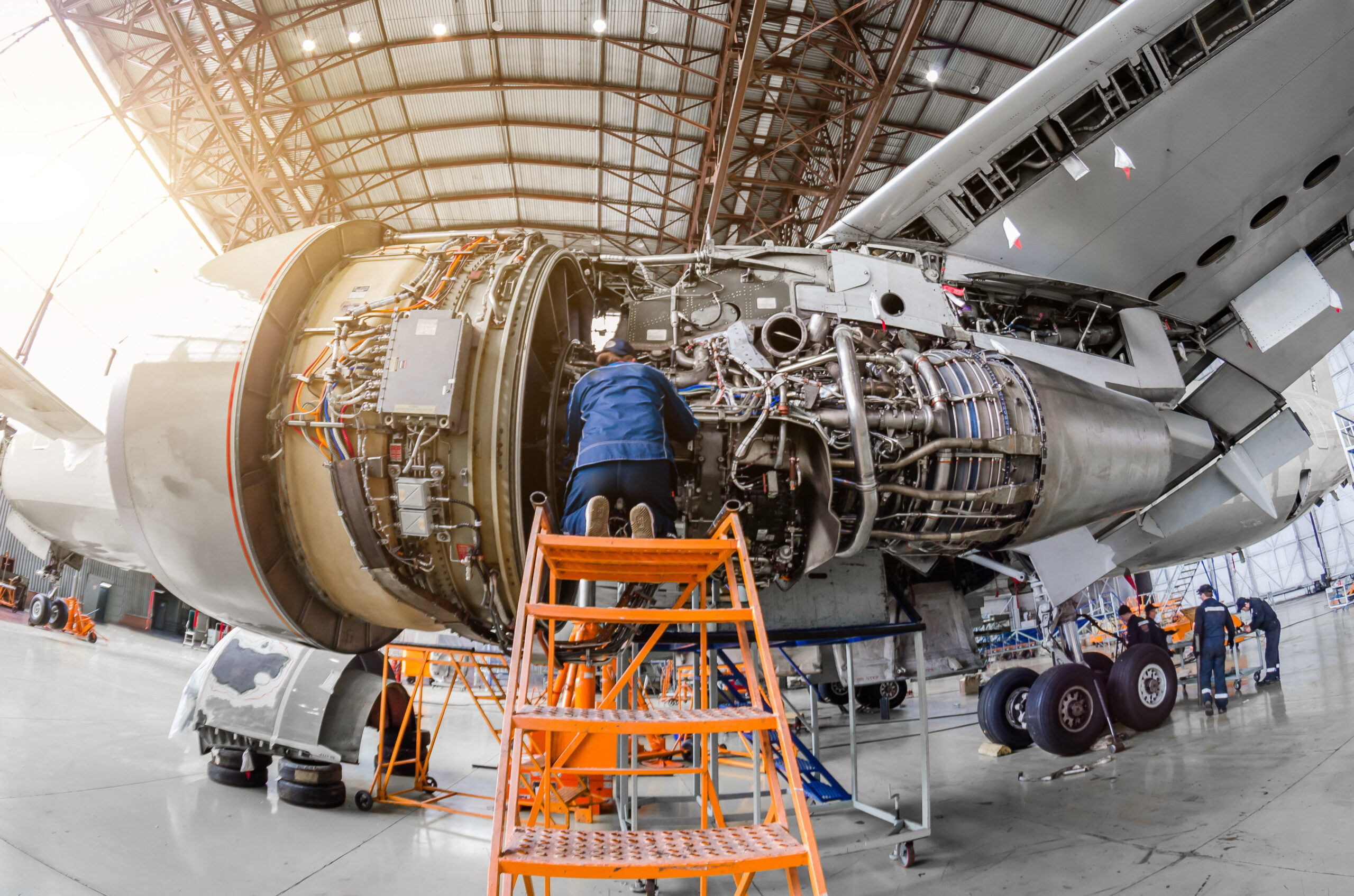 Specialist mechanic repairs the maintenance of a large engine of a passenger aircraft in a hangar.